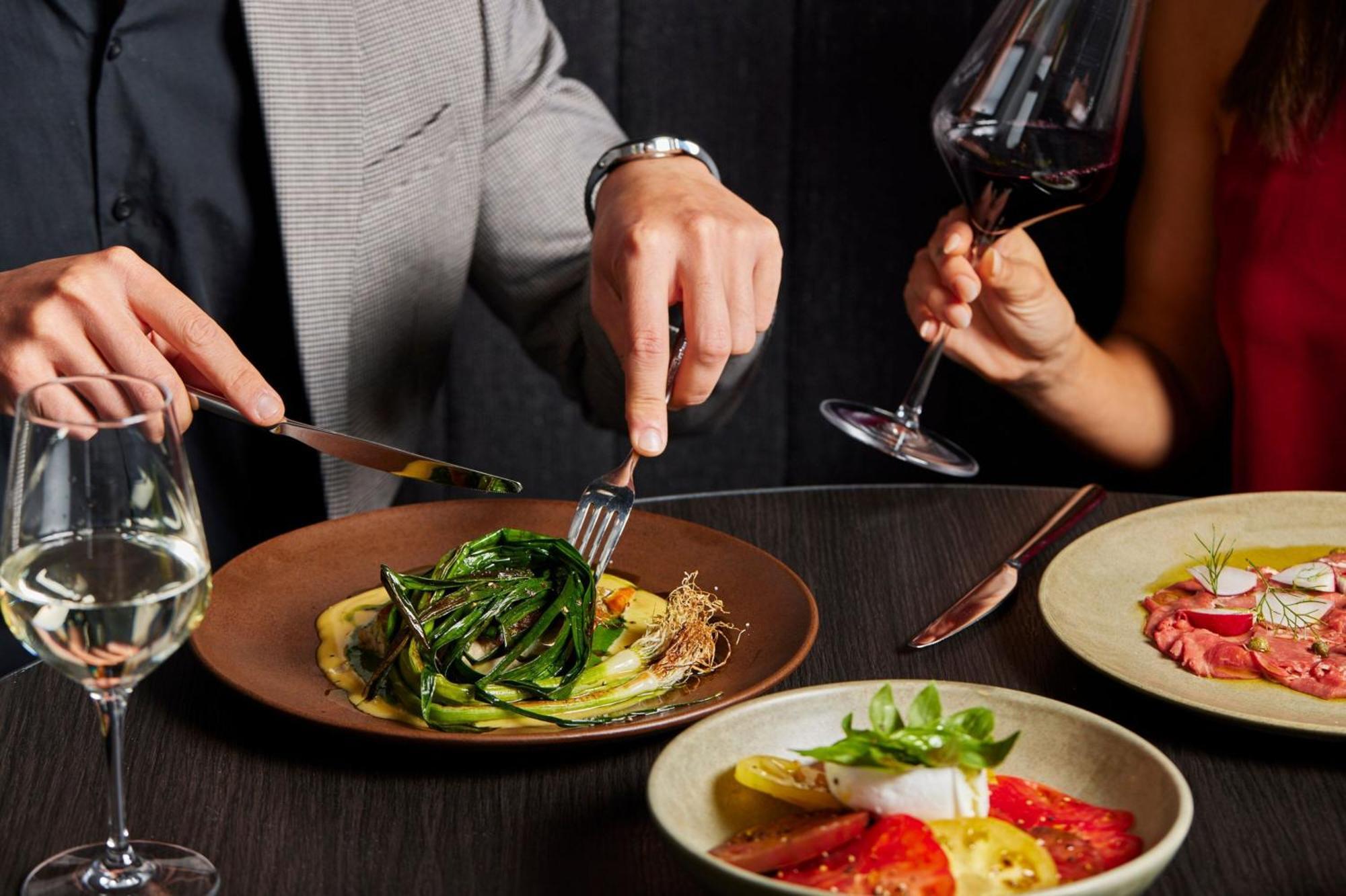 Melbourne Marriott Hotel Docklands Dış mekan fotoğraf A man using a knife and fork to cut into a meal